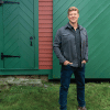 man standing in front of a large green garage