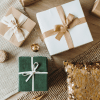 Three gift boxes on a table wrapped in holiday themed wapping paper