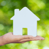 a hand holding a miniature white house