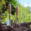 Garden hoe and garden pick sticking up in soil in garden