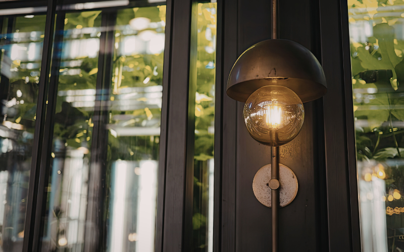Ambient lighting old fashioned dim circular yellow bulb outside black door cottagecore