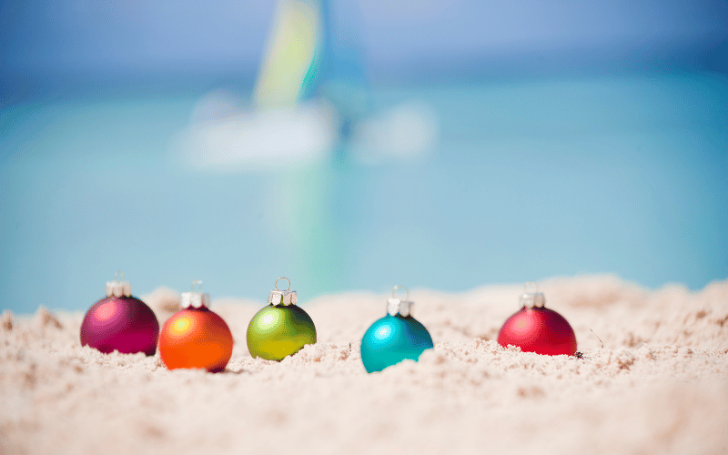 Multi Colored Christmas Bulbs on the sand at the beach