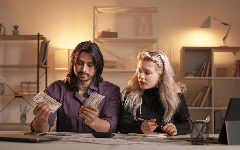 Couple counting money and doing budget at the table 