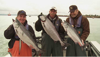 Go West For Salmon Three men on a boat holding fish