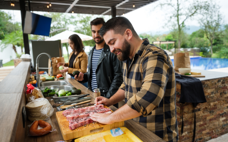 Group of young people preparing food outdoors for a backyard cookoff 