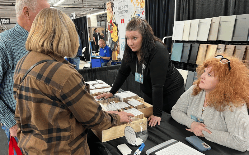 Boomer couple speaking to two interior designers at a booth at the Colorado Garden and Home Show