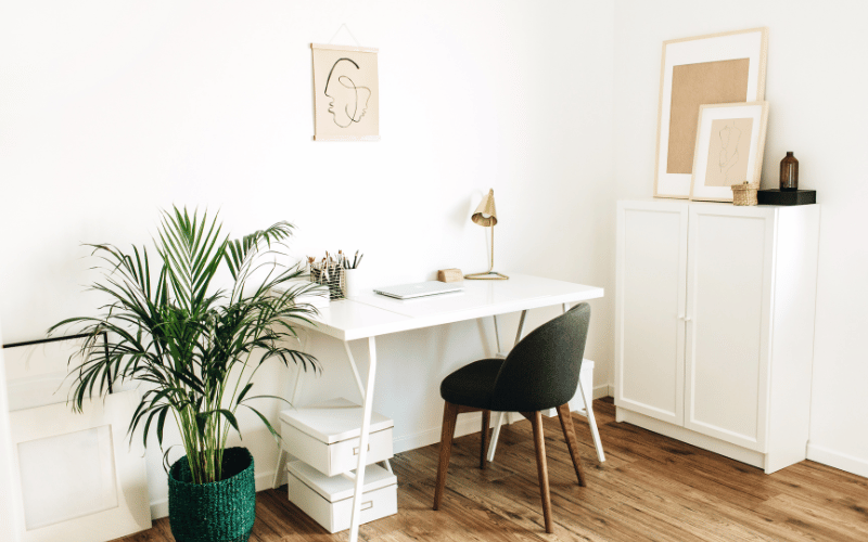 white desk and black work from home office chair along with home storage surrounding desk