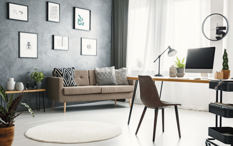 Thoughtfully designed modern home office with desk, couch, houseplants and desk lamps in front of big open window