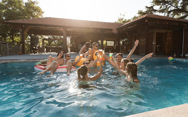 Group of young people enjoying a backyard pool party