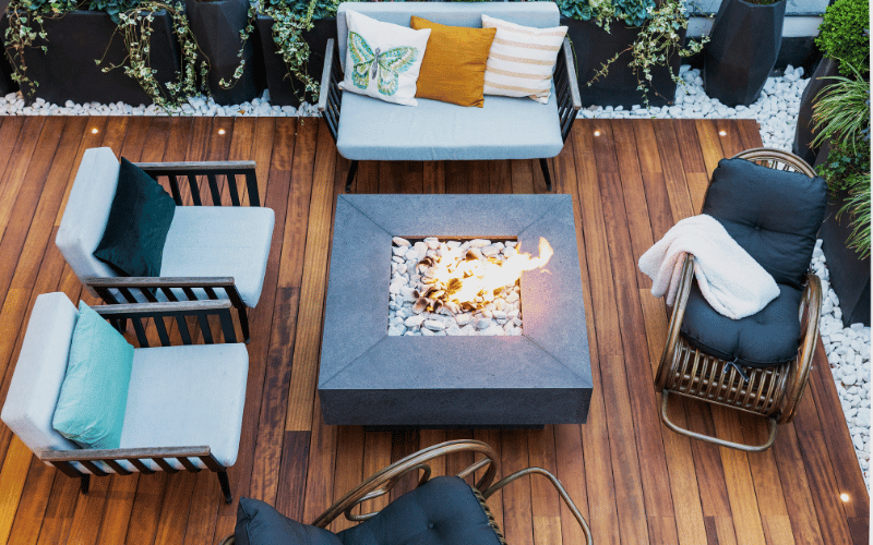 Birds eye view looking down at patio with second hand patio pillows and modern outdoor fire pit