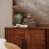 a wooden chest of drawers with a plant placed on top