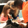 mother and child filling out a form at the Birmingham Home Show