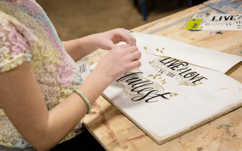 close-up-of-female-hands-making-home-decor-sign-live-life-to-the-fullest