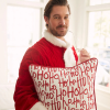 Craig Conover thumnail wearing red Santa Suit clutching red and white ho ho ho pillow