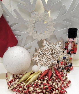 Katherine Brooke Design big white bulb with pile of snowflakes, hanging gold icicle ornaments and red and gold beads with nutcracker