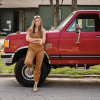 Kim Wolfe standing in front of red pick up truck thumbnail