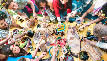 Group enjoying outdoor potluck in backyard