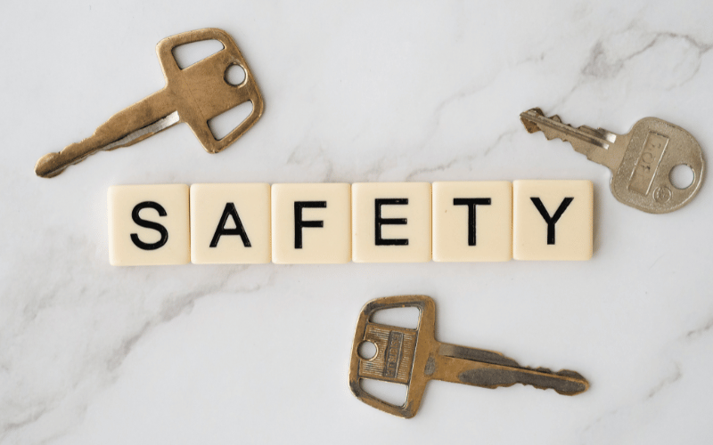 the word safety written with scrabble tiles surrounded by 3 brass rusted house keys