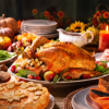 Close up of Thanksgiving Turkey on full table with potatoes, gravy and apple pie.