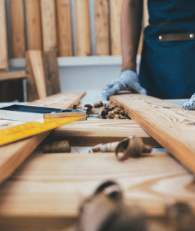 Someone DIY cutting wood planks with gloves