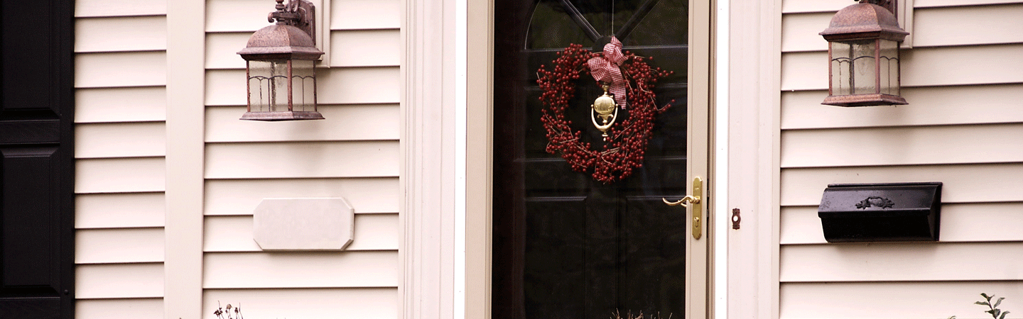 Front door with mailbox and red wreath