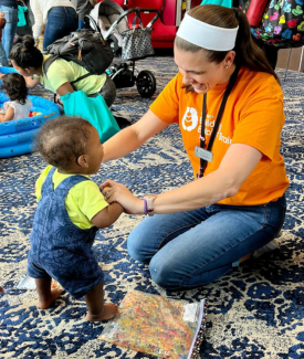 Gwinnett Building Babies’ Brains Young Black Baby and White Female 30s Woman holding babies hands as they stand up 