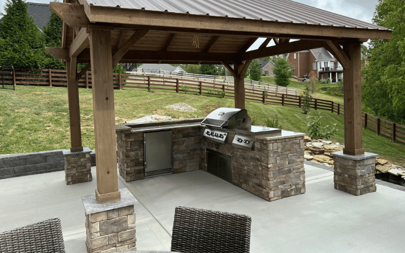 gazebo over top stone barbecue  in residential backyard
