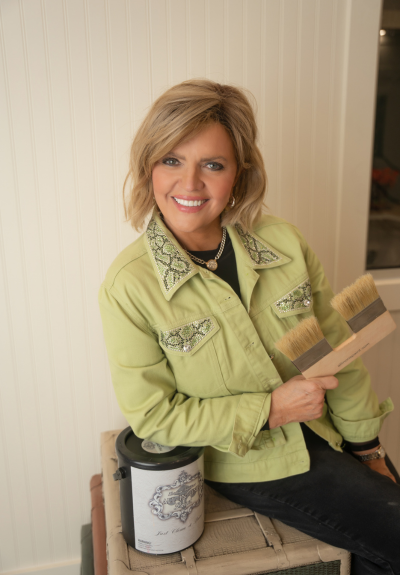 Paula Blankenship Headshot leaning on paint can holding paint brush