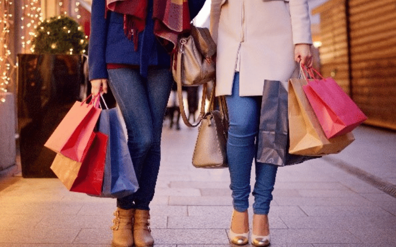 Two women standing with many shopping bags in their hands 