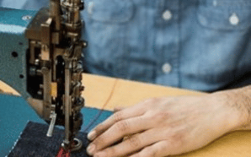 a man using a sewing machine to stitch fabric together 