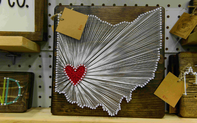 Image of wooden artican craft showing Ohio state with string art over Cincinnati