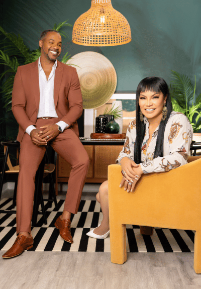 Mike Jackson and Egypt Sherrod posing over black and white striped carpet and yellow chair