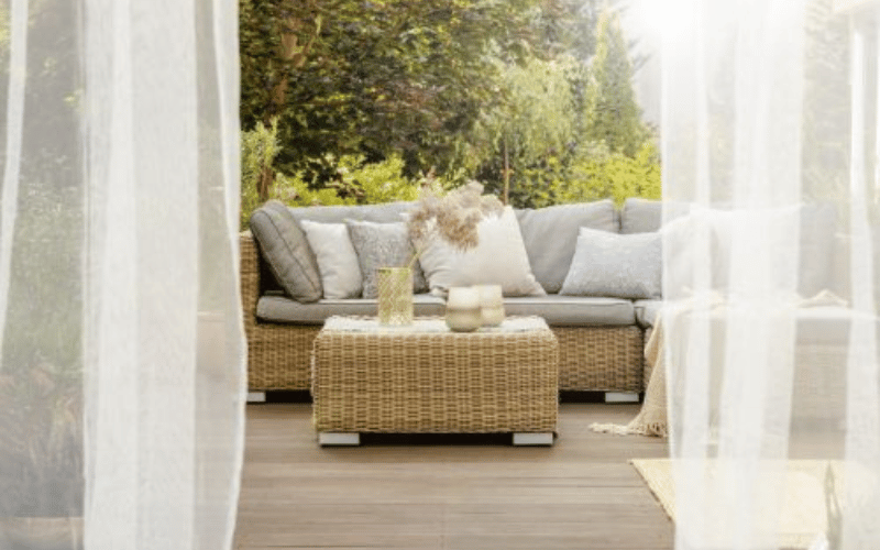 a large outdoor patio and garden with wicker chairs