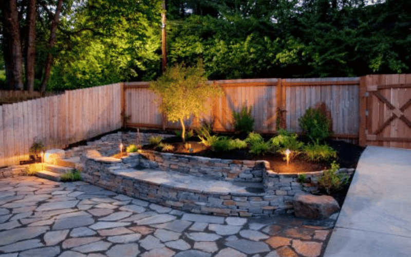large backyard patio with stones and trees 