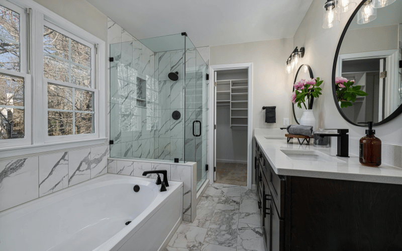 a large white bathroom with marble floors and large window 