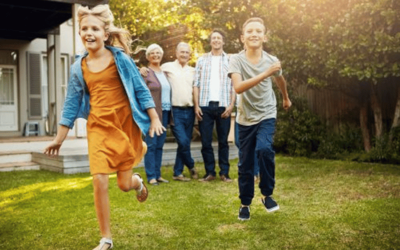 parents and children standing in a green backyard garden