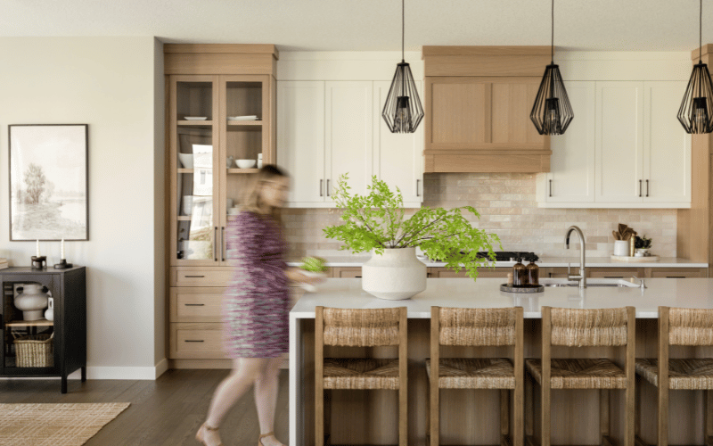 a large open kitchen with bar stool chairs and a hanging light feature 