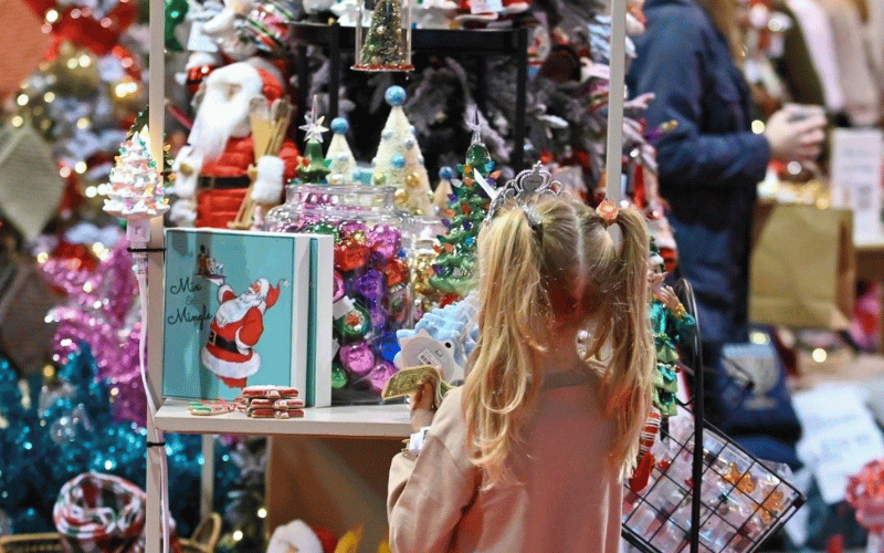 young girl standing in front of Christmas decorations 