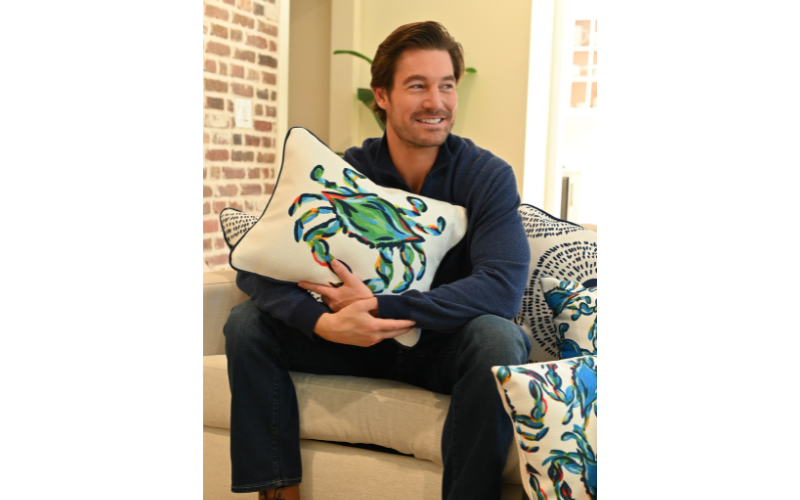 Craig Conover holding a pillow with a crab print 