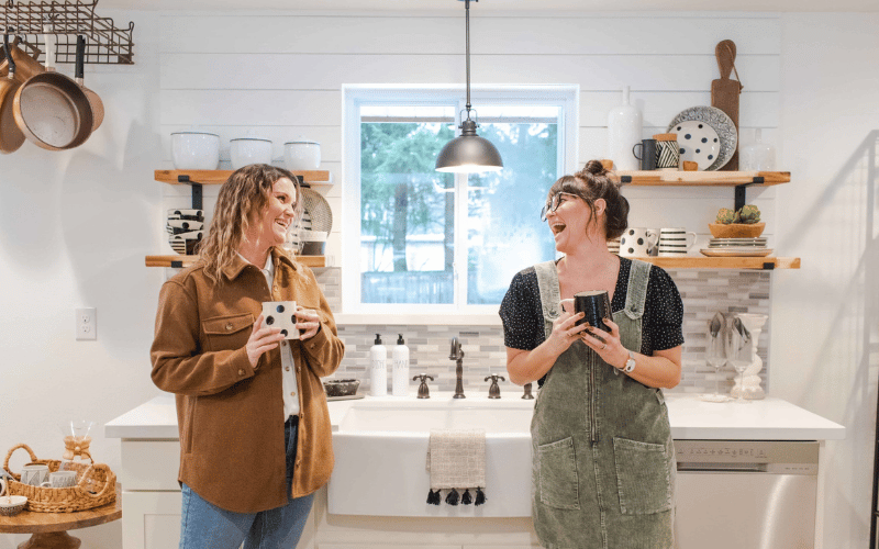 two women standing in a large white kitchen