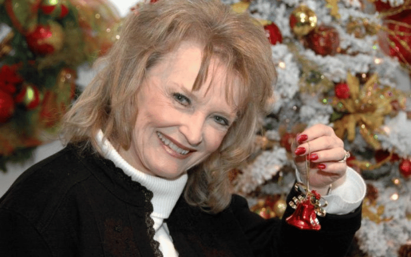 women with red nail polish holding a Christmas ornament 