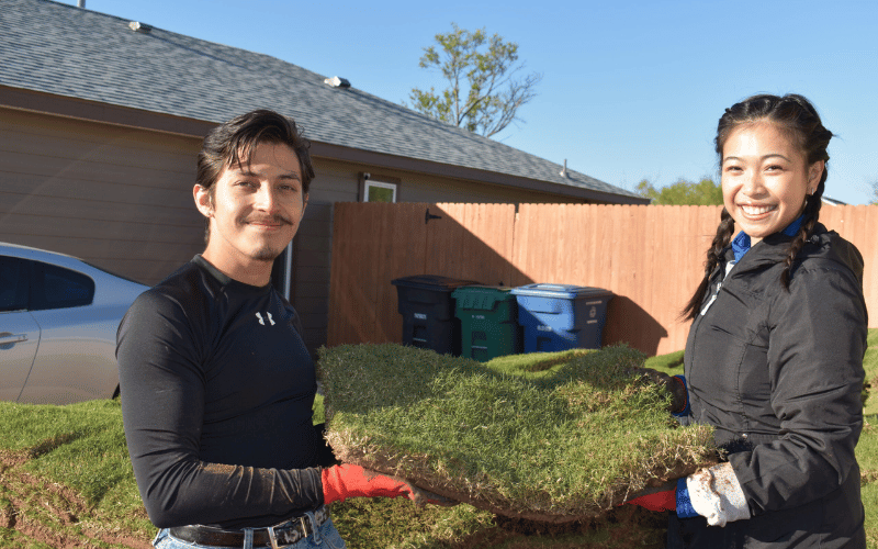 two teenagers holding soil in their hands 