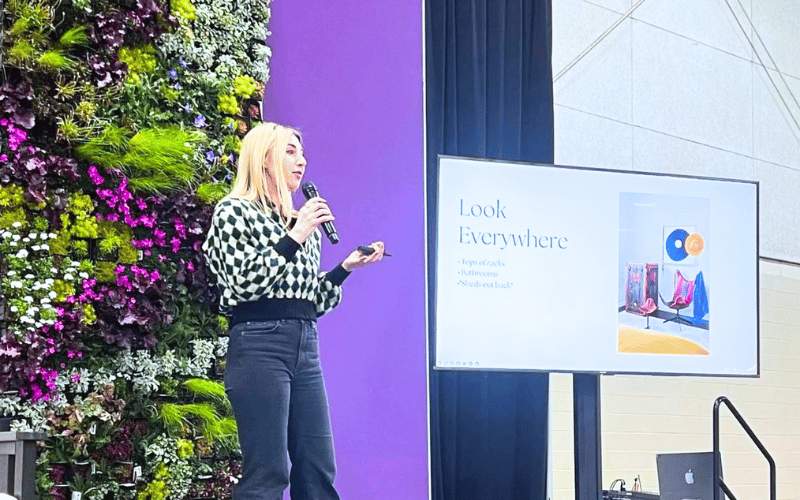 Virgina Chamlee speaking on stage with a microphone in her hans 