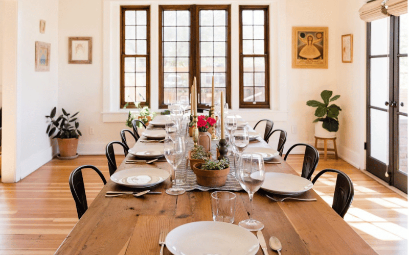 long wooden table with dinnerware and decorations