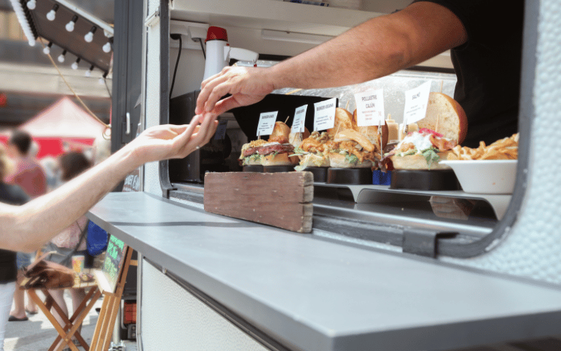 man handing out food at a food truck
