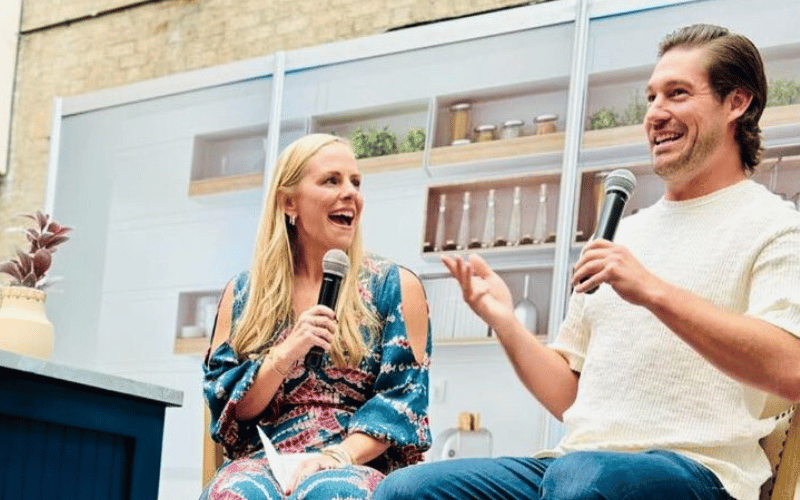 man and woman speaking on stage with microphones