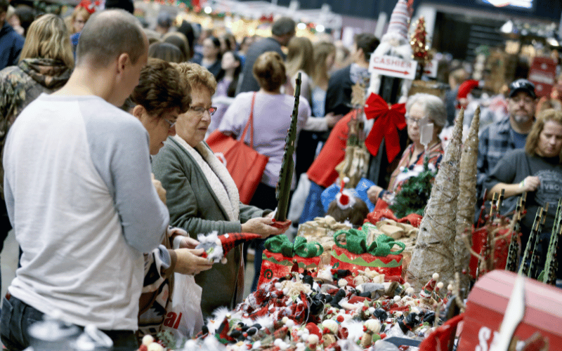 busy trade show floor with vendors selling Christmas items 