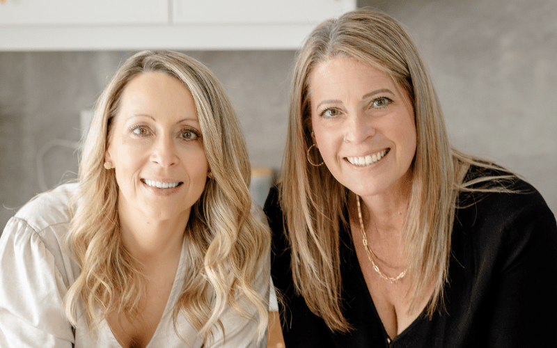 two women standing side by side posing for a picture 