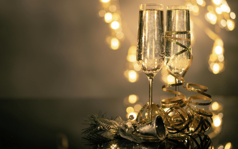 two champagne flutes on a glass table 