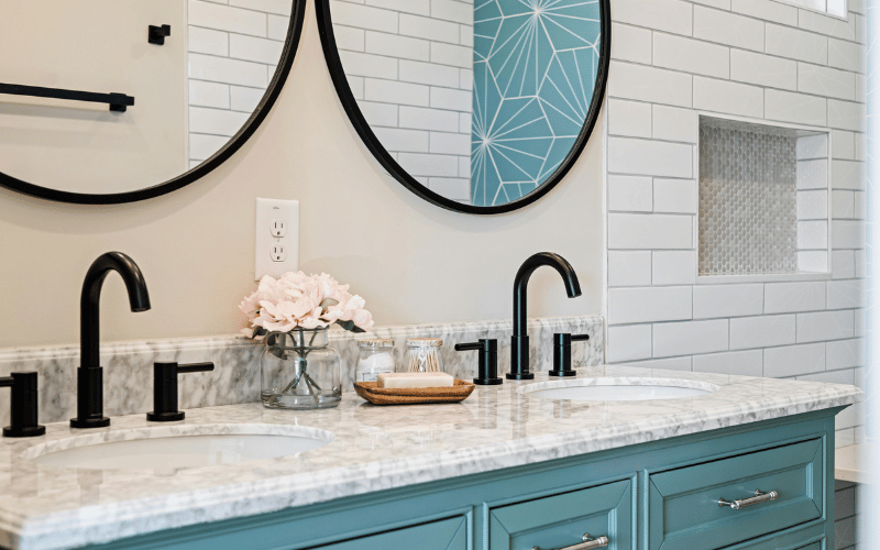 large white bathroom with marble countertop and teal accents 